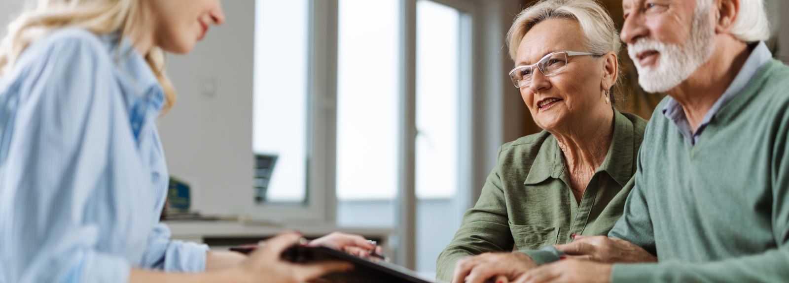 An older couple speaking with a solicitor across a desk